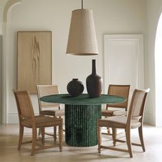 a dining room table with chairs and vases on it