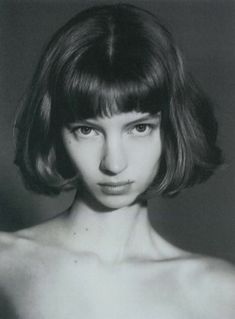 a black and white photo of a woman with short hair