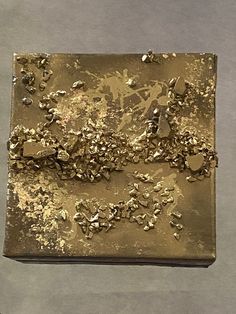 a piece of metal with gold flakes on it