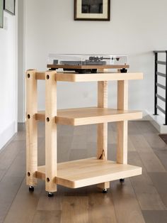 a record player sitting on top of a wooden shelf