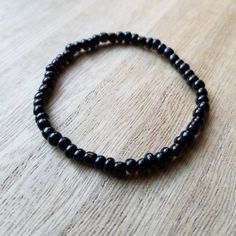 This bracelet is made up of glass seed beads in an opaque black color. Perfect for stacking together, wearing alone, or pairing with a chunky bracelet. The options are endless! (Bracelet sold individually). Great as gifts! Size shown: 7 inches Strung on pre-stretched bracelet material. SIZINGThe sizing chart is the standard for stretch bracelets. Since material is pre-stretched there is some leeway or give as far as how the bracelet fits on your wrist. TIP FOR MEASURING: Best rule of thumb when Casual Black Round Beads Friendship Bracelets, Casual Black Round Beads Friendship Bracelet, Casual Black Friendship Bracelet With Black Beads, Casual Black Friendship Bracelets With Round Beads, Minimalist Adjustable Black Beaded Bracelets, Minimalist Black Beaded Bracelets, Casual Black Beaded Friendship Bracelets, Black Friendship Bracelets With Round Beads, Black Round Beads Friendship Bracelets