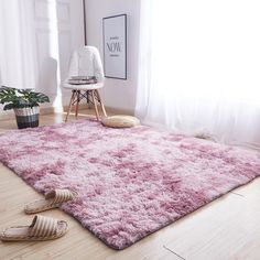 a pink area rug on the floor next to a chair