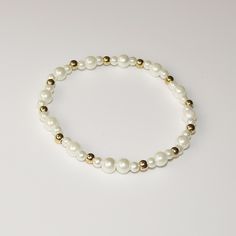 Add a touch of elegance to your wrist with this beautiful small white beaded bracelet. The bracelet features round beads and white marbles, giving it a charming and unique look. The gold spacers add a touch of luxury to the piece, making it perfect for any occasion. Handmade in the United States, this bracelet is a perfect addition to any jewelry collection. The ball/bead chain type adds a comfortable fit to the bracelet, making it suitable for all-day wear. This bracelet is perfect for those who love beaded jewelry and want to add a touch of sophistication to their wardrobe. The bracelet is versatile and can be paired with any outfit, making it a must-have accessory for any fashion-forward individual. Cheap White Bracelets With Gold Beads, Affordable White Stretch Bracelet With Spacer Beads, White Resizable Beaded Bracelets, White Beaded Bracelets With Gold Beads For Gifts, White And Gold Beads Bracelet, Adjustable White Beaded Bracelets With Gold Beads, White Beaded Bracelets With Tiny Round Beads, White Bracelets, Gold Bead Bracelets