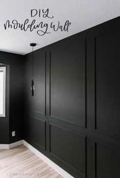 a room with black painted walls and white trim on the wall, there is a large window