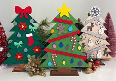 three wooden christmas trees with decorations on them