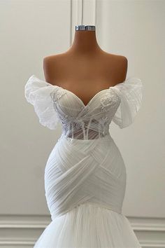 a white wedding dress on a mannequin