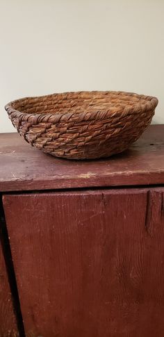 a basket sitting on top of a wooden cabinet