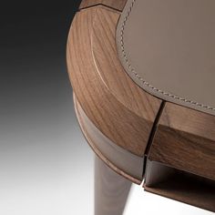 a close up of a wooden table with a leather seat cushion on the top and bottom