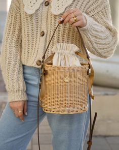 a woman is carrying a wicker bag