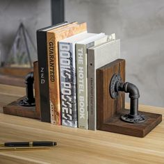 two books are placed next to each other on a wooden table with a pen and pencil