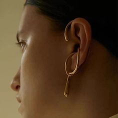 a close up of a person wearing earrings and looking at the back of their head