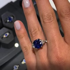 a woman's hand with a ring on it and a blue stone in the middle