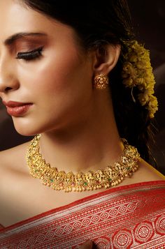 Drawing inspiration from South Indian temple artistry, this necklace set is a true masterpiece. Its design intricately captures the motifs of an Indian goddess, making it a stunning piece of art. The accompanying earrings are equally exquisite, adding a touch of elegance and sophistication to the set. Finish: 22KT Gold Plating Material: Silver, Copper Alloy Color: Gold Size: Free Size, Adjustable Closure Type: Draw String Box Contains: 1 Necklace, 1 Pair Earrings Elegant Jewelry For Navratri Festival, Elegant Temple Necklace With Matching Earrings, Elegant Gold Bridal Necklace For Rituals, Fusion Style Festive Jewelry Sets With Elegant Design, Elegant Design Temple Necklace For Festive Season, Elegant Temple Necklace For Festive Season, Elegant Temple Jewelry Kundan Necklace, Elegant Jewelry Sets With Intricate Design For Navratri, Elegant Temple Necklace With Peacock Design As Gift