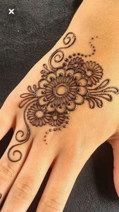 a woman's hand with henna tattoos on it