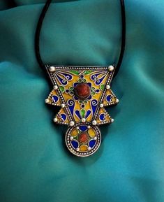 Ancient Berber talisman (herz) in sterling silver, enamelled in blue, green and yellow color. and decorated with a real coral cabochon. Height: 7 cm. Width: 5.5 cm. Leather: 54 cm. ++Material: sterling silver 925, real coral cabochon. ++Weight: 31.8 grams. ++ Origin: Morocco 1970s. Free worldwide shipping by DHL. I am always open to offers for one of my items, so please contact me if you would like to make an offer. Don't hesitate to contact me for any questions. All items advertised for sale ar Traditional Red Heart-shaped Jewelry, Amulet Pendant Jewelry For Rituals, Ritual Amulet Pendant Jewelry, Yellow Locket Jewelry As Gift, Yellow Locket Jewelry For Gift, Handmade Medallion Amulet Jewelry, Handmade Amulet Style Jewelry For Festivals, Handmade Medallion Jewelry For Ceremonial Use, Handmade Amulet Jewelry For Festivals