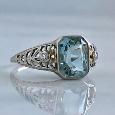 Edwardian Aquamarine & Diamond 18KW Filigree Ring | Etsy Fine Jewelry Sapphire Ring For Wedding With Intricate Design, Sapphire Ring With Intricate Design For Wedding, Wedding Sapphire Ring With Intricate Design, Elegant Oval Ring With Intricate Design, Elegant Engraved 14k White Gold Ring, Wedding Engraved Diamond Ring With Gemstone, Elegant Oval Engraved Ring With Intricate Design, Luxury Silver Hallmarked Filigree Ring, Luxury Oval Filigree Ring With Intricate Design