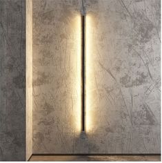 a wall mounted light in the corner of a room with concrete walls and flooring