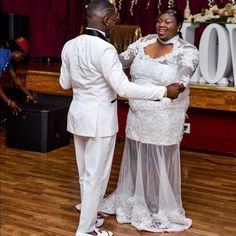 a man and woman standing next to each other on a wooden floor