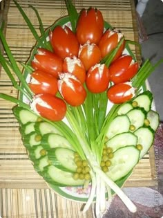 a bunch of tomatoes and cucumbers sitting on top of a bamboo tablecloth