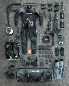 an assortment of scuba gear and equipment laid out on the ground in front of it