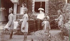 an old black and white photo of children in front of a house with luggage on the ground