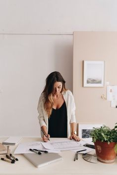 a woman sitting at a desk with papers and pens