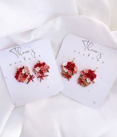 two pairs of red and pink flower earrings on top of a white card with the words, mom's best wishes