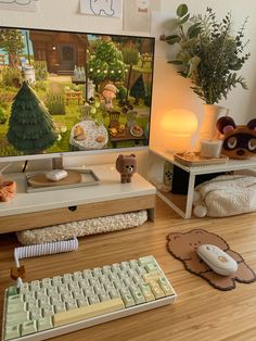 a computer desk with a keyboard and mouse on it in front of a television screen