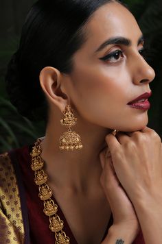 This opulent intricacy worked in geru gold plated silver alloy has its charm in its regal detailing. The monotonicity of gold is eased by adding the pretty pearls accentuating the charm of this temple work beauty. Necklace Closure - Adjustable Dori Earrings Closure - Push Back Style Tip - Style this with classic banarasi sarees, lehengas or indo western wear dresses. A perfect match with almost any traditional classic. This one comes straight off a nani inspired jewelery wardrobe and offers hint Gold Brass Jhumkas For Wedding, Gold Temple Jewelry With Hallmark, Gold Hallmarked Temple Jewelry, Gold Filigree Chandbali Necklace, Gold Hallmarked Kundan Necklace For Diwali, Heavy Gold Jewelry For Celebration, Ceremonial Yellow Gold Bridal Necklace With Latkans, Elegant Temple Necklace With Latkans As Gift, Temple Jewelry Necklace For Wedding