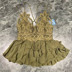 Intimately Free People Size Xs Cami Top Lace Crochet Olive Sparrow Green Ruffle Elevate Your Bohemian Wardrobe With This Beautiful Free People Intimately Adella Cami Top. The Top Features A Stunning Lace Fabric Type With A Delicate Ruffle Accent, Perfect For Any Occasion. The V-Neckline And Strappy Sleeve Type Add A Touch Of Sophistication, While The Adjustable Strap Feature Ensures A Comfortable Fit. This Olive Sparrow Green Camisole Comes In Xs Size, Regular Fit, And Is Made Of A Combination O Summer Lace Camisole Bra Friendly, Summer Lace Top Bra Friendly, Fitted Ruffle Camisole For Vacation, Fitted Ruffles Camisole For Vacation, Lace Tops With Ruffles For Vacation, Vacation Camisole With Delicate Straps And Fitted Design, Fitted Summer Camisole With Ruffles, Fitted Camisole With Delicate Straps For Vacation, Fitted Vacation Tops With Delicate Straps