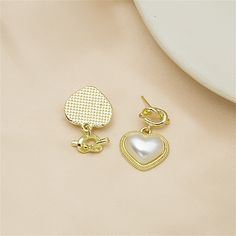 Take your accessory style up a notch with these drop earrings that feature a knot detail and heart-shaped pearls for a luxe look. 0.71" W x 0.87" L 18k gold-plated copper / pearL Gold Teardrop Heart Earrings In Elegant Style, Gold Teardrop Heart Earrings, Gold Pearl Earrings For Anniversary On Valentine's Day, Elegant Gold Teardrop Heart Earrings, Valentine's Day Gold Pearl Earrings For Anniversary, Gold Heart-shaped Pearl Earrings For Pierced Ears, Heart-shaped Gold Pearl Earrings For Pierced Ears, Gold Pearl Heart Earrings For Weddings, Elegant Gold Heart-shaped Pearl Earrings