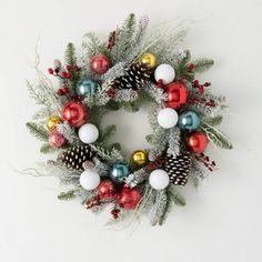 a christmas wreath with ornaments and pine cones