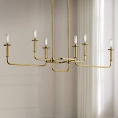 a large brass chandelier with five candles hanging from it's center rod