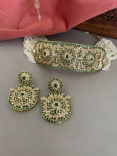 A beautiful green jadau choker set string in tiny white beads will set you apart. This high quality trendy jewelry set is a must have in your collection.  The Jadau workmanship was introduced by the Mughals and is now practiced and perfected by the skilled craftsman of Rajasthan in India.  Details: Necklace Width-1.5 Inches Earrings Length-2.25 Inches Weight of Each Earring-12 gms All products are manufactured using traditional skills from our rich heritage of crafts.  The process of these craft Green Meenakari Sets For Ceremonial Occasions, Green Kundan Ceremonial Sets, Green Kundan Temple Jewelry Set, Ceremonial Green Kundan Sets, Ceremonial Green Kundan Bridal Sets, Green Ceremonial Jewelry Set For Festive Occasions, Green Festive Jewelry Set For Ceremonial Occasions, Festive Green Ceremonial Jewelry Set, Festive Green Jewelry Set For Ceremonial Occasions