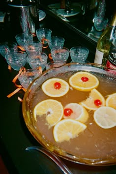 there is a pie with lemons and cherries on the top, surrounded by wine glasses