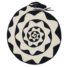 a black and white round rug with an abstract design on the center, in front of a white background