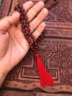 The beads of this mala are 100 % authentic and original. Tibetan / Mahayana style mala. Can be worn as a necklace or a wrap bracelet. Mala is made in traditional way with knots between the beads. Total beads 108+1 There are two kinds of sandalwood Red ( Rakta ) and white (Shweta). Rosaries of red sandalwood are useful for propitiating the goddess whereas white are useful for the gods. Red sandalwood is the symbol of Brahma and blessed by Lakshmi. It enlightens the super consciousness, provides i Traditional Gemstone Beads Mala For Festival, Traditional Festival Mala With Gemstone Beads, Holistic Mala With 108 Beads For Festival, Holistic Mala With 8mm Beads For Festivals, Traditional Mala With 108 Beads For Festival, Handmade Red Mala For Healing, Hand-strung Red Mala As A Gift, Red Hand-strung Mala As Gift, Red Gemstone Beads Mala As Gift