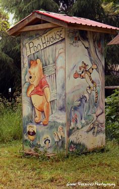 a painted outhouse with winnie the pooh on it