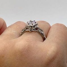 a woman's hand holding an engagement ring