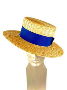 Straw boater hat made with 8/9 millimeters natural straw braid. Embellished with a 50 millimeters wide blue grosgrain ribbon. You can choose the grosgrain ribbon in the color you like best - (in this ad the grosgrain is azure) Measurements in centimeters are 34 x 32. Crown height 9. Brim length 7. These measurements may have some slight variation depending on the size of the hat. For its elaboration we only use very good quality and resistant straw braids. In our workshop in the Pyrenees we sew Summer Boater Hat With Flat Brim For Garden Party, Summer Boater Hat With Curved Brim For Kentucky Derby, Summer Boater Hat For Kentucky Derby With Curved Brim, Summer Vintage Fedora With Flat Brim, Classic Boater Hat For Beach And Kentucky Derby, Chic Blue Straw Hat With Curved Brim, Elegant Natural Straw Hat Bands, Wide Brim Toquilla Straw Boater Hat For Garden Party, Adjustable Flat Brim Boater Hat For Garden Party