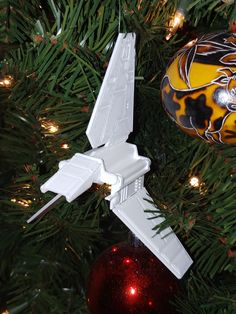 an ornament hanging from a christmas tree with a star wars fighter jet on it