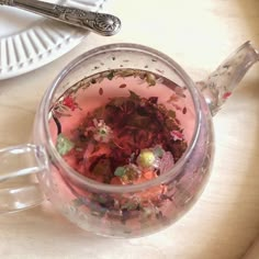 a cup filled with lots of different colored confetti on top of a table