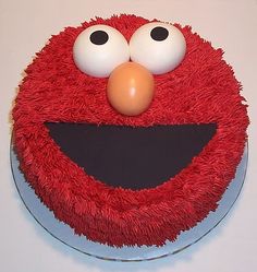 a red cake decorated with an elmo face