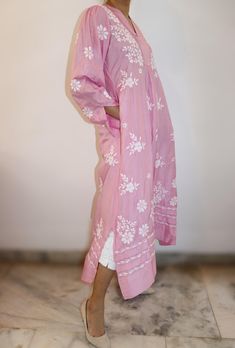 Exquisite pure silk Chikankari dress in a lovely cherry blossom shade. Features a pleated yoke with a split neckline and elegant poet sleeves adorned with cuffs. The 47/48-inch length is complemented by short side slits for ease of movement. Vintage Chikankari embroidery adds timeless charm, while convenient pockets offer practicality. A perfect blend of traditional craftsmanship and modern comfort. Sizes : S - fits bust 34 M - fits bust 36 L - fits bust 38 XL - fits bust 40 0X - fits bust 42 Prewashed. Preshrunk. Wash - All silks are to be dry cleaned. However as an option, one also bucket wash them separately in light detergent and cold water. Line Dry, Light iron for best results. Spring Dresses With Chikankari Embroidery In Straight Kurta Style, Elegant Pink Summer Kurta, Spring Long Sleeve Kurta With Pintucks, Spring Long Sleeve Pintuck Kurta, Straight Kurta With Set-in Sleeves For Spring, Traditional Spring Tunic Midi Dress, Elegant Fitted Kurta With Pintucks, Pink Long Sleeve Dress With Chikankari Embroidery, Traditional Long Sleeve Midi Dress For Spring