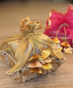 two small bags with seashells in them on a table