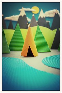 an origami teepee with mountains in the background