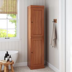 a tall wooden cabinet sitting next to a bath tub in a room with white walls