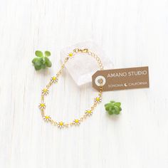 This delightful Daisy Chain Bracelet is the perfect accessory to brighten up any outfit. Its 7" length provides a comfortable fit, and the 14k gold plated brass and enamel materials give it a luxurious look. Add a touch of charm and happiness to your day with this cheerful bracelet. 7" length. Made of 14k gold plated brass + enamel. Dainty Adjustable Yellow Jewelry, Dainty Gold-tone Charm Bracelet Gift, Enamel Jewelry For Spring Gifts, Spring Enamel Jewelry As Gift, Spring Enamel Jewelry For Gifts, Spring Gift Enamel Jewelry, Spring Metal Jewelry With Adjustable Chain, Adjustable Yellow Jewelry With Chain, Enamel Bracelet Jewelry With Lobster Clasp