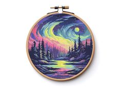 a cross - stitch pattern with an image of a forest and the moon at night