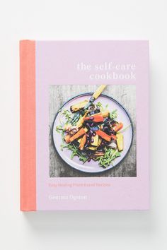 the self - care cookbook is sitting on top of a white table with a pink cover